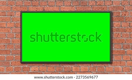 Picture frame on a green screen placed on a red brick wall