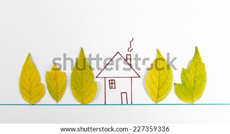 Autumn leaves with painted house isolated on white