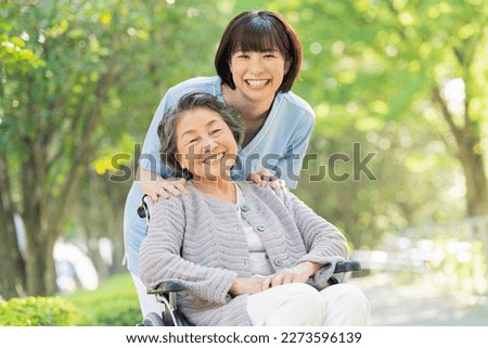 Senior woman in wheelchair indoors and Female health care worker in her 30s