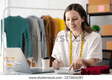 Beautiful girl clothing designer, the owner of the shop, she is the owner of a female fashion clothing store and designs clothes and cutting the dress by herself, selling products online.