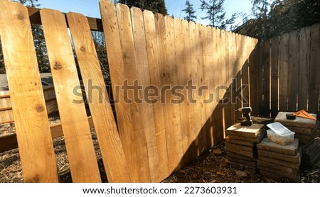 Building a Cedar Picket Wood Fence Scene Stringers Backer Rails  No People Box of Screws Power Tools Screwdriver Framing Square Royalty-Free Stock Photo #2273603931