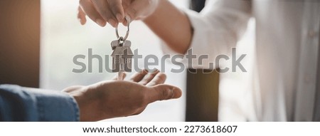 Realtor agent giving a key of apartment to new owner after signed lease agreement.