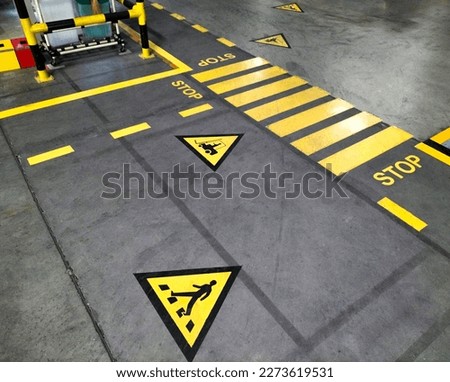 Industrial building corridor painted yellow between parallel yellow lines on abstract cement background. Sidewalk Negotiation Safety Concept