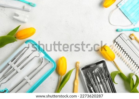 Frame made of dentist's tools and tulips on white background. Hello spring