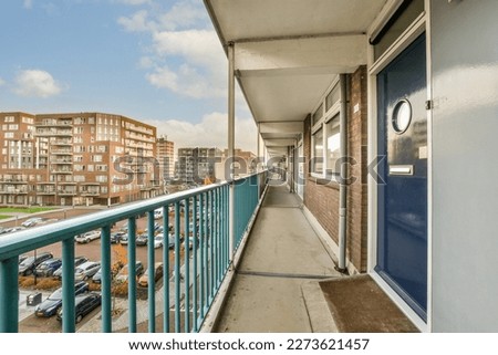 a balcony with cars parked on the sidewalk and buildings in the background, taken from an apartment building's balcony Royalty-Free Stock Photo #2273621457