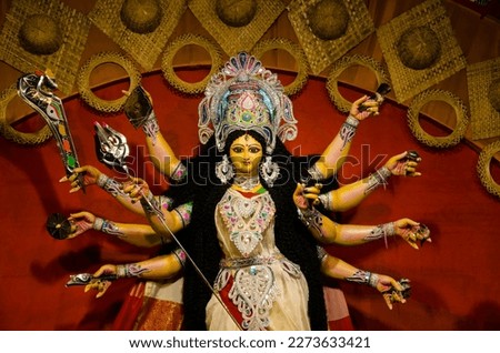 Goddess Durga idol at decorated Durga Puja pandal, colored light, at Kolkata, West Bengal, India. Durga Puja is biggest religious festival of Hinduism and is now celebrated worldwide. Royalty-Free Stock Photo #2273633421