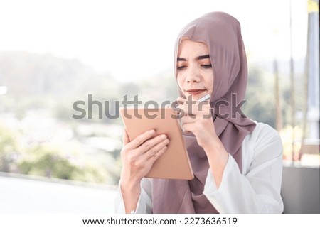 muslim female smile using a tablet for work