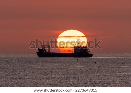 Sunrise at sea, a ship appears in the picture