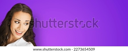 Happy excted smiling woman in white confident cloth looking aside. Business advertisement concept. Brunette businesswoman, isolated on violet purple background. Royalty-Free Stock Photo #2273654509