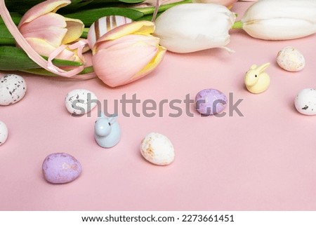 Easter composition of pink and white tulips, ribbon, cute bunnies and eggs on a pink background. Tulips bouquet, spring flowers. Content for Easter holiday. Flat lay, side view, close up, copy space