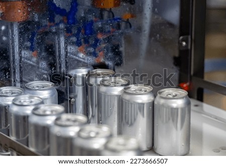 Conveyor with aluminium cans. Beverage factory. Filled aluminium cans. Royalty-Free Stock Photo #2273666507