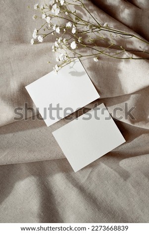 Minimal aesthetic business brand template, empty paper cards and flower on a neutral beige linen textile background