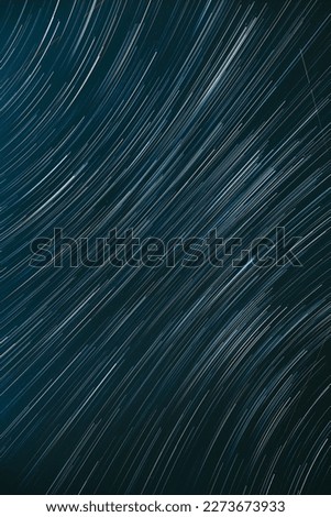 Meteors Trace On Night Dark Blue Sky Background. Spin Of Unusual Amazing Stars Effect In Sky. Abstract Bewitching Illusion Of Star Trails. Soft Colors.