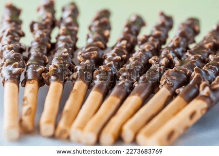 Chocolate covered pretzel sticks on a baking sheet.