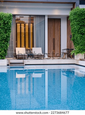 Luxury 5 star hotel pool in Asia with chairs. Royalty-Free Stock Photo #2273684677