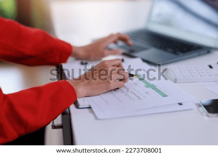Concept of business invesment or woman working,Closeup businesswoman checking her invesment plan with analyzing document and business investment graph data by using calculator and computer laptop Royalty-Free Stock Photo #2273708001