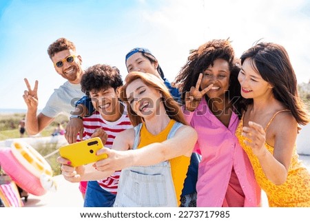Multiethnic group of happy friends bonding and having fun at the beach on summer vacation - Multiracial real authentic people spending time together at the sea, concepts about youth and summertime Royalty-Free Stock Photo #2273717985