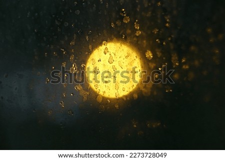 the moon with very beautiful colors plus the rain behind a glass makes it look beautiful