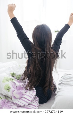 Cute teenage girl stretching on the bed in her room having fun.
