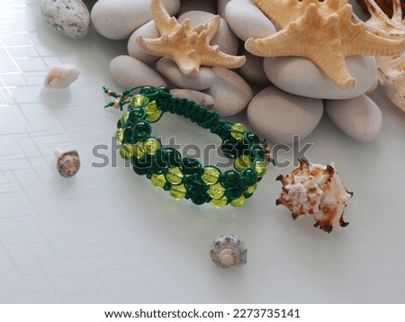 Colorful friendship bracelet and sea stones. Hippie colorful bracelet on sea stones background