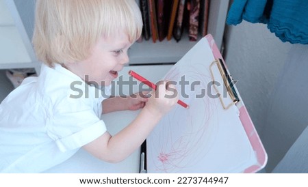 A picture of a little boy painting a picture.