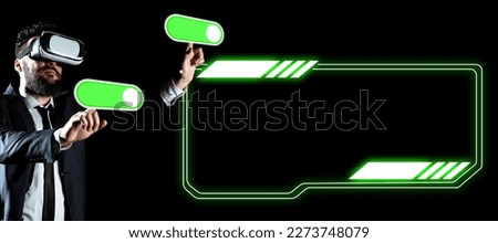 Businessman in black office suit standing wearing VR glasses and looking at technological message. Man pressing virtual buttons with his both fingers. Futuristic style.