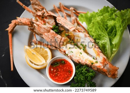spiny lobster food on white plate, fresh lobster or rock lobster seafood with herb and spices lemon coriander parsley lettuce salad, lobster for cooking food and seafood sauce - top view Royalty-Free Stock Photo #2273749589
