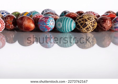 A close-up view of the colorful Easter eggs and their reflections in the glass.