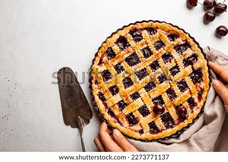 Delicious homemade classic cherry pie with a flaky crust on white background, top view