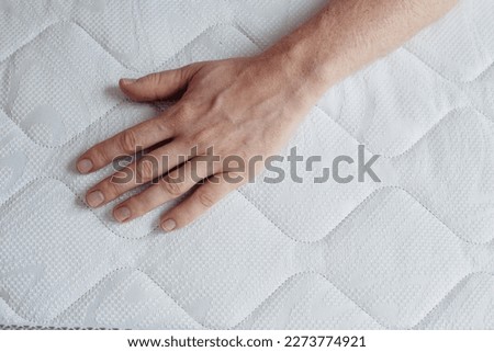 hand lies on a white blanket, advertising photo