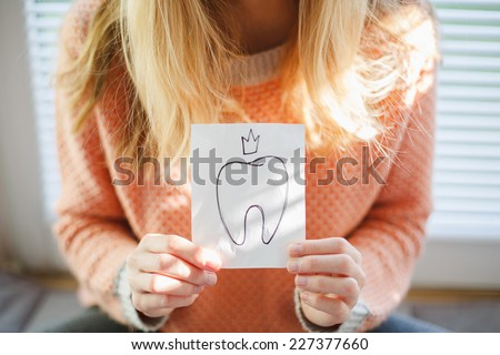 woman holding a paper with a first baby tooth picture