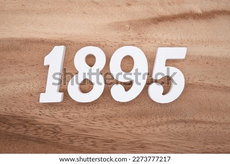 White number 1895 on a brown and light brown wooden background.