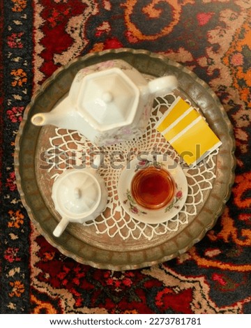 Top view photography of a female hand taking photo of a traditional Persian tea ceremony.
