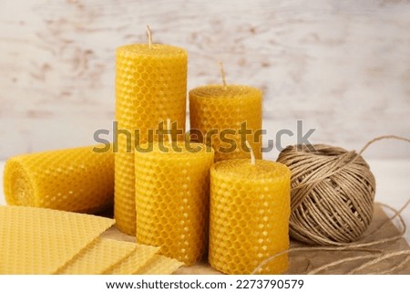 Stylish elegant beeswax candles, wax sheets and twine on table Royalty-Free Stock Photo #2273790579
