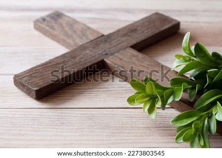 Wooden cross with sprigs of boxwood, easter symbol of life and immortality, concept 