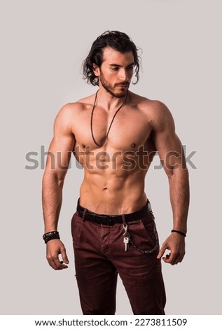 Confident, attractive shirtless muscular young man with open vest on Royalty-Free Stock Photo #2273811509