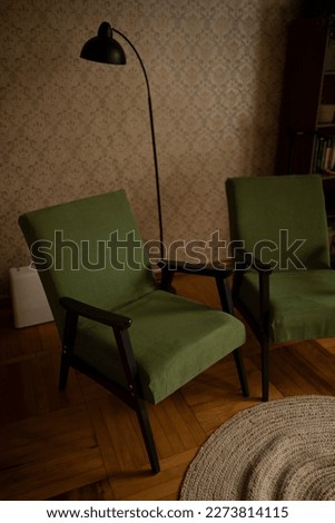 a seaworthy armchair with green upholstery and wooden planks in the interior of the living room. two green armchairs in the room Royalty-Free Stock Photo #2273814115