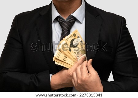 A man in a suit who wants to trade in 50,000 won bills in Korea. Royalty-Free Stock Photo #2273815841