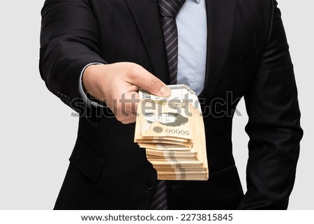 A man in a suit who wants to trade in 50,000 won bills in Korea. Royalty-Free Stock Photo #2273815845