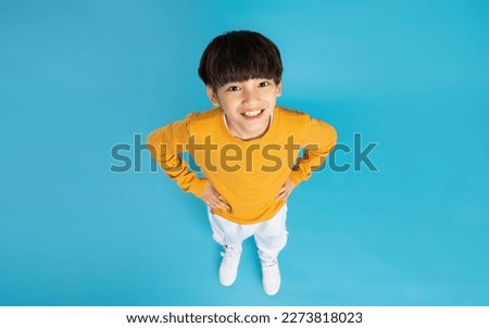 Asian boy portrait posing on blue background Royalty-Free Stock Photo #2273818023