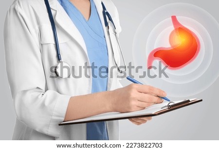 Treatment of heartburn and other gastrointestinal diseases. Doctor with clipboard on light background, closeup. Stomach illustration Royalty-Free Stock Photo #2273822703