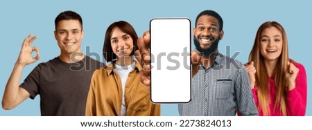Smiling millennial multiracial people show smartphone with empty screen, make success and ok gesture, recommend website, app isolated on blue background, studio. Device for chat and communication