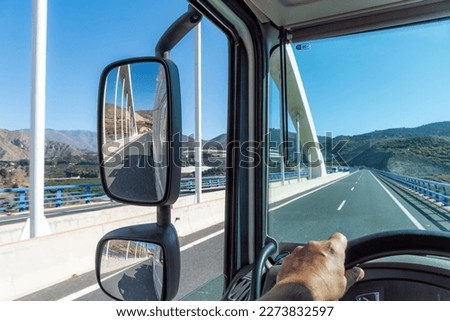 View from the driving position of a truck of the road where it drives when passing over a bridge and of the rear view mirrors. Royalty-Free Stock Photo #2273832597