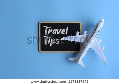 Toy plane and chalkboard with text TRAVEL TIPS. Travel and transportation concept