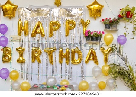 Phrase HAPPY BIRTHDAY made of golden balloon letters in decorated room
