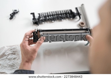 Specialist repairs the printer cartridge, fuser unit close-up. printer repair technician. Royalty-Free Stock Photo #2273848443