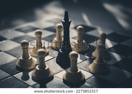 black king surrounded by white pawns on a chessboard. the leader of one team is captured by members of the other team. dictator under siege concept. top view Royalty-Free Stock Photo #2273852317