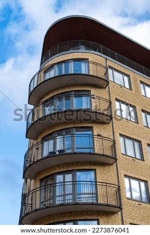 Brick apartment building with retro rounded corner windows and balconys.