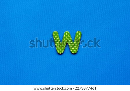 letter w on blue paper background  Royalty-Free Stock Photo #2273877461