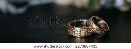 Two unusual, custom-made gold wedding rings lie on the table. Banner for website header design with copy space.